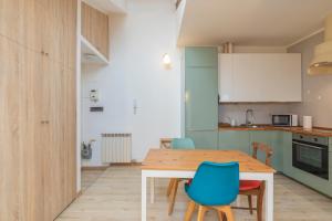 a kitchen and dining room with a wooden table and chairs at [IHost Apartment] - Adige 17 in Milan