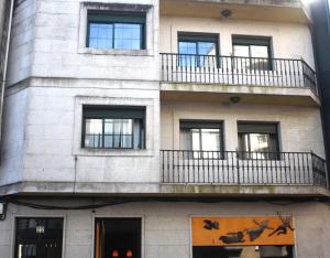 a building with windows and a balcony with animals on it at MAR DE FORA in Cambados