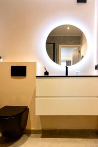 a bathroom with a black toilet and a mirror at Studio By Aimee in Ostend