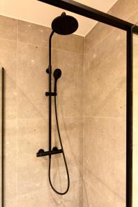 a shower with a shower head in a bathroom at Studio By Aimee in Ostend