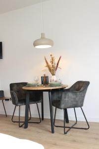 een eettafel met 2 stoelen en een lamp bij Apartment mit 2 Betten in Flughafennähe in Paderborn