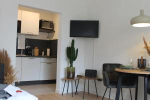 een woonkamer met een keuken en een tafel met een cactus bij Apartment mit 2 Betten in Flughafennähe in Paderborn