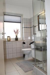 een badkamer met een toilet, een wastafel en een raam bij Apartment mit 2 Betten in Flughafennähe in Paderborn