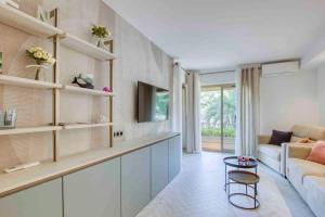 ein Wohnzimmer mit einem Sofa und einem Tisch in der Unterkunft Appartement piscine/tennis accès privé plage in Sanary-sur-Mer
