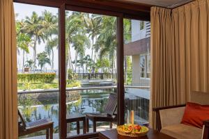 a room with a view of a pool and palm trees at Lake Canopy Alleppey in Mararikulam