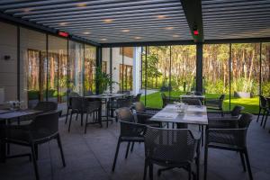 a restaurant with tables and chairs and windows at Hotel Morski Widok in Krynica Morska
