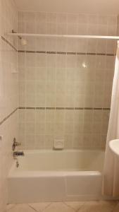 a bathroom with a white tub and a sink at Budget Motor Inn- Stony Point in Stony Point