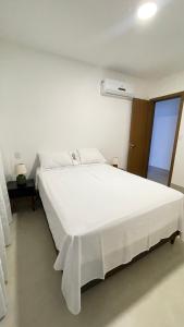 ein großes weißes Bett in einem Zimmer mit Fenster in der Unterkunft Apto JP 301 para 2 pessoas in Vitória
