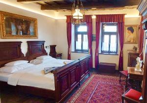 a bedroom with a large wooden bed and windows at Antik Vendégház in Nagyvisnyó