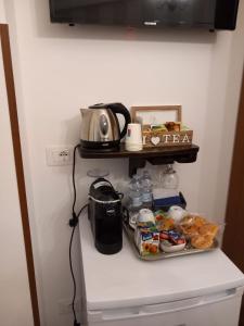 Bed & Breakfast Elisabeth في تروبيا: ثلاجة مع ميكروويف وبعض الطعام على رف