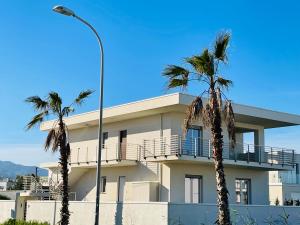 a building with palm trees in front of it at Villa Ale in Torregrotta