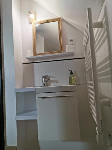 a bathroom with a sink and a mirror at Chopin in Les Haies