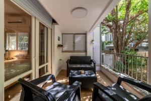 a living room with a couch and chairs on a balcony at Modern 2br 6 guets - ben gourion Blvd area in Tel Aviv