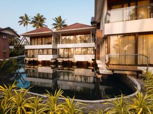 a building with a pool in front of it at Lake Canopy Alleppey in Mararikulam