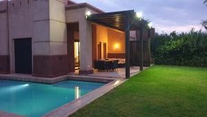 une maison avec une piscine dans la cour dans l'établissement Villa de standing à Marrakech Complexe résidentiel Apple Garden, à Marrakech