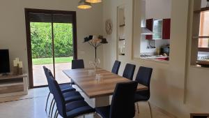 une salle à manger avec une table en bois et des chaises bleues dans l'établissement Villa de standing à Marrakech Complexe résidentiel Apple Garden, à Marrakech