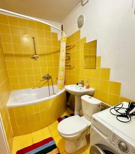 a yellow bathroom with a toilet and a sink at 4-км в центрі міста in Rivne