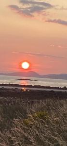 einen Sonnenuntergang am Strand mit Sonnenuntergang über dem Meer in der Unterkunft Glenashdale 28 A 1/R Boyd Street Largs KA308LE in Largs