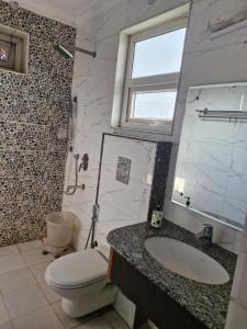 a bathroom with a sink and a toilet and a window at Hotel Wedlock 39 in Gurgaon