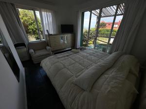 ein Schlafzimmer mit einem großen Bett und einem großen Fenster in der Unterkunft Hotel Boutique Donatella Mare art. in Punta del Este