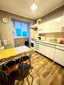 a kitchen with a table and chairs in it at 4-км в центрі міста in Rivne