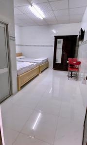 een kamer met twee bedden en een tafel en stoelen bij Nhà Nghỉ MỸ THUẬN in Long Hai +1 foto