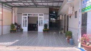 een toegang tot een gebouw met planten en bloemen bij Nhà Nghỉ MỸ THUẬN in Long Hai