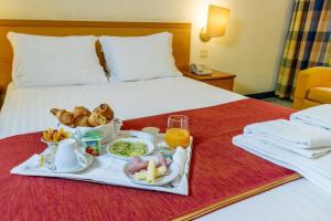 ファフェにあるFlag Hotel Guimarães-Fafeのベッドの上に食べ物のトレイ