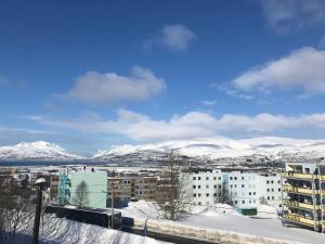 a view of a city with snow covered mountains at Your home away from home, apartment 2 in Tromsø