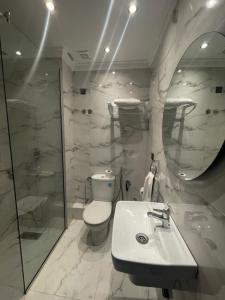 a bathroom with a toilet and a sink and a mirror at Hôtel Amouday in Casablanca