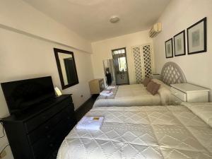 a bedroom with two beds and a dresser at Hotel Boutique Donatella Mare art. in Punta del Este