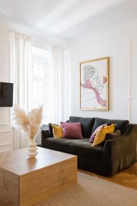 a living room with a black couch and a coffee table at MARIANNA'S OLD TOWN RESIDENCE in Ljubljana