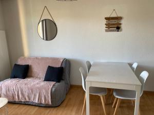 ein Wohnzimmer mit einem Tisch und einem Sofa in der Unterkunft T2, accès direct plage, proche thalasso in Cabourg