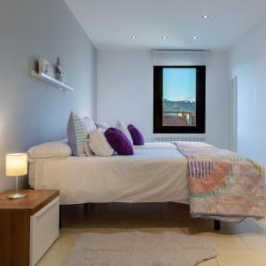 1 dormitorio con cama con almohadas y ventana en Apartamentos Naredo, en Villaviciosa