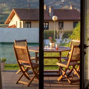 a wooden table and chairs on a patio at Apartamentos Naredo in Villaviciosa