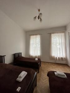 a room with two beds and two windows at Guest House - Tbilisi Center in Tbilisi City