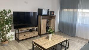 a living room with a flat screen tv and two tables at PLAYA POSTIGUET 2 in Alicante
