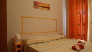 - une chambre avec un lit et une couverture rayée dans l'établissement Rifugio di Stazzo Holiday home for groups of 20 people, à Santa Tecla