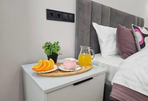 a tray of oranges and juice on a bedside table at ЖК Комфорт Сити Бизнес, 2 room Apartment 47 in Almaty