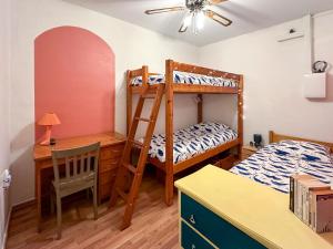 a bedroom with a bunk bed and a desk at ART appartement climatisé, 3 chambres, 5 lits, 1 min du port, cuisine équipée and jeux de société in Port-Vendres