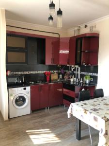 een keuken met rode kasten en een wasmachine bij Драхтик in Jerevan