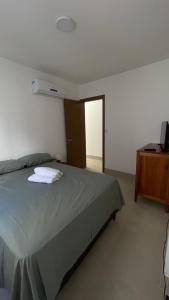 Schlafzimmer mit einem Bett und einer Kommode mit einem TV in der Unterkunft Apto JP 301 para 2 pessoas in Vitória