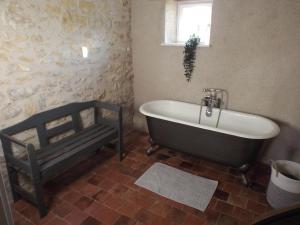 een badkamer met een bad en een raam bij Gîte de la Grange in Colombiers