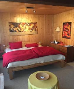ein Schlafzimmer mit einem großen roten Bett und einem Tisch in der Unterkunft Ferienhaus Susanne in Nagel