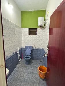 a bathroom with a blue toilet and a sink at The Last Stop Backpackers Hostel in Auroville