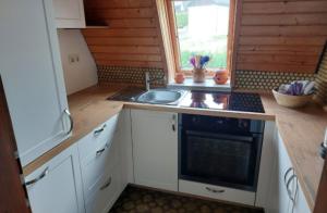 eine kleine Küche mit Spüle und Herd in der Unterkunft Ferienhaus Susanne in Nagel