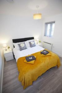 a bedroom with a large bed with a yellow blanket at Spire View Apartment*SO15 Sleeps 4-Secure Parking in Southampton