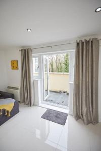 a bedroom with a large window with curtains at Spire View Apartment*SO15 Sleeps 4-Secure Parking in Southampton