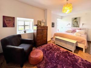 a bedroom with a bed and a chair at Pequeno Paraiso-1RoomLet in São Brás de Alportel