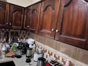 a kitchen with wooden cabinets and a counter top at Berakah cozy Rentals in Freetown
